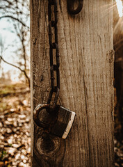 a single lock dangles for a rusty chain on a post