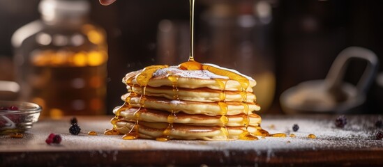 Stack of pancakes, syrup, and berries on wooden surface