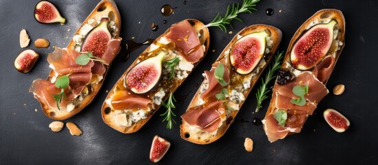 Four bread slices with figs and cheese on black surface - Powered by Adobe