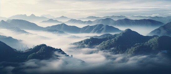 Mountains shrouded in mist under a clear blue sky