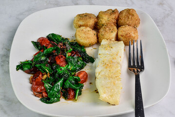 seasoned baked cod  with  scallops and sauteed vegetables