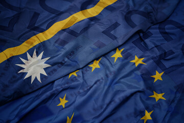 waving colorful flag of european union and flag of Nauru on a euro money banknotes background. finance concept.