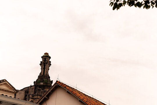 Torre no alto de uma casa de telhado com telhas de barro. 