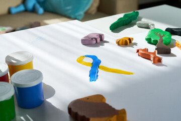 Background image of Down syndrome awareness sign painted in sunlight with childs toys, copy space