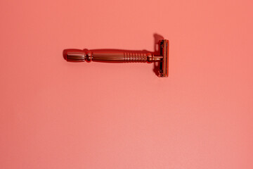 Metal razor on a pink background. Razor close-up.