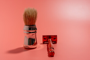 Metal razor and pen brush on a pink background. Razor close-up.