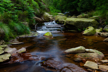 Water streaming over rocky cascades, Deep forest waterfall small waterfall with blurred water on...