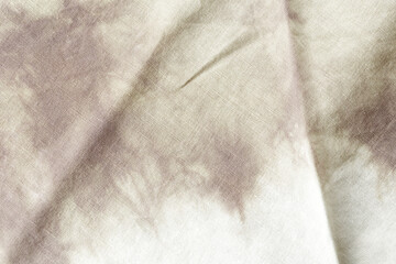 A piece of fabric with a pattern of brown and white. The fabric is wrinkled and has a faded...