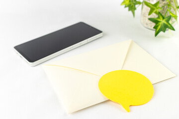 スマートフォンと封筒と付箋。メールやSNSのイメージ