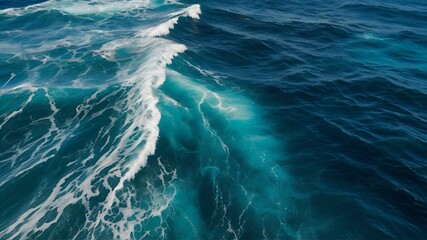 close up of strong blue waves breaking in the open sea on a sunny afternoon