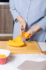 Senior Caucasian woman peeling pumpkin in home cuisine