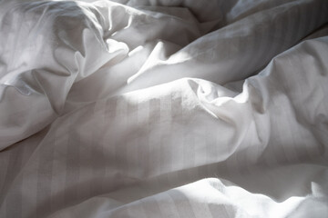Top view of sheets and pillows. White linens. Bed texture
