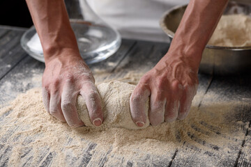 The process of preparing dough. A cook kneads dough from whole grain wheat flour in the kitchen....