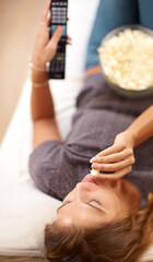 Woman, sofa and popcorn with remote and relax in home, food and watching on weekend. Subscription,...