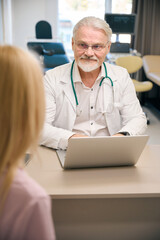 Woman patient consulting with male physician in clinic office