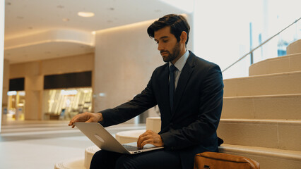 Skilled investor working or planing strategy by using laptop at stair. Professional business man...