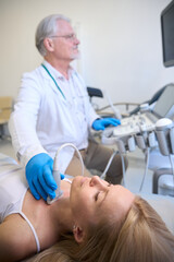 Female getting thyroid ultrasound exam in hospital