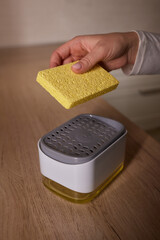 a sponge is sitting on top of a soap dispenser on a sink
