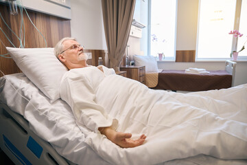 Hospitalized mature male lying in medical ward - 797076423