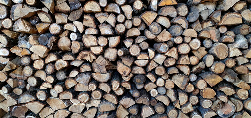 a lot of firewood stacked against the wall, wooden texture background