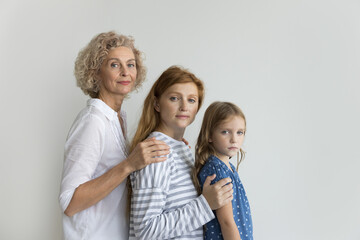 Pretty multi-generational women posing in studio, photography symbolizes continuum of life, passage of time within family, transmission of values, traditions, experiences from one generation to next