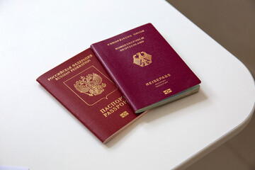 Close up of a German and a Russian passport on white table