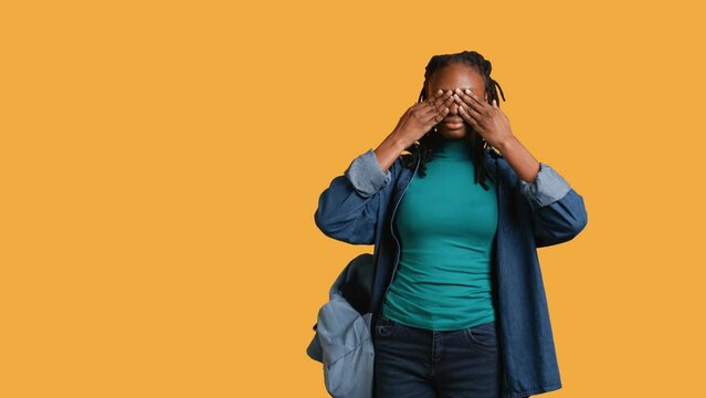 African american woman covering eyes, ears and mouth with hands, imitating the three wise monkeys. Girl doing do not see, do not hear and do not speak gesturing concept, studio background, camera B