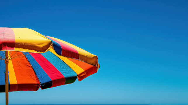 vibrant beach umbrella against blue sky on sunny day for leisure and travel concepts, with copy space for text
