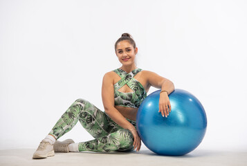 Fototapeta na wymiar woman demonstrates fitness exercises. beautiful body-positive woman in light green sportswear performs fitness exercises on a white background in full growth