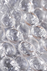 The textured surface of bubble wrap packaging, showcasing its bubbly patterns and transparent appearance. Bubble wrap textures offer a playful and tactile backdrop