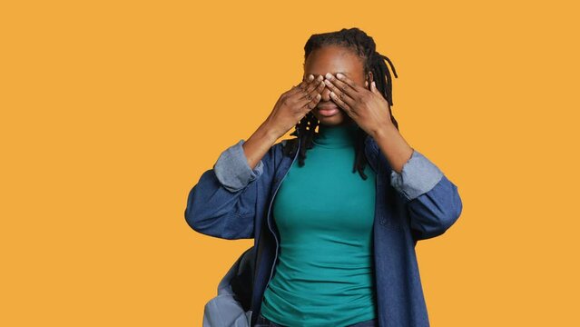 African american woman covering eyes, ears and mouth with hands, imitating the three wise monkeys. Girl doing do not see, do not hear and do not speak gesturing concept, studio background, camera A