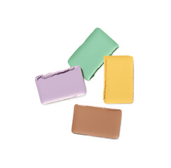Different color correcting concealers on white background, top view