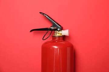 One fire extinguisher on red background, top view