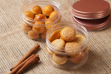 Sesame cake in a plastic jar on a brown cloth background, photographed with studio lights