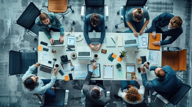 Top view angle of meeting atmosphere of office workers at meeting table with stationry report file.