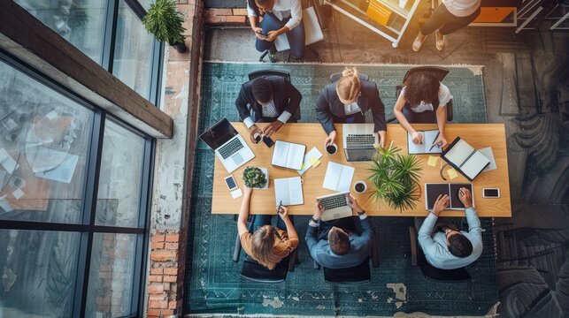 Top view angle of meeting atmosphere of office workers at meeting table with stationry report file.