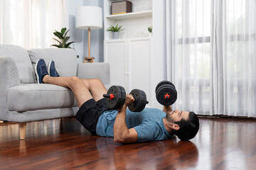 Athletic body and active sporty man using furniture for effective targeting muscle gain with weight...
