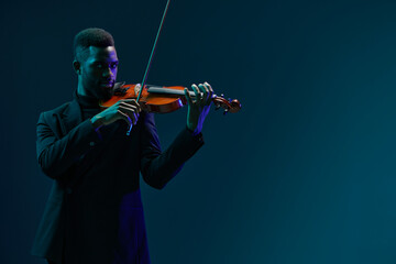 Classic Violin Performance by a Man in Elegant Black Suit on Vibrant Blue Background for Music and...