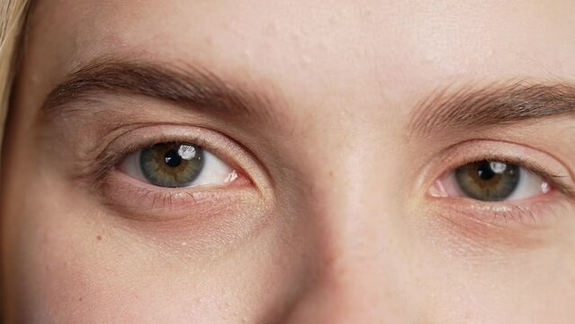 Half face with eyes, brows of pretty teenager or woman, natural beauty. Young girl with american appearance looking at camera. Close-up charming green eye.