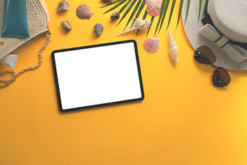 Digital tablet with blank screen, sunglasses, straw hat and seashells on yellow background - 797234801