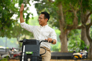 Friendly male worker riding bicycle and waving hand as greeting someone. People and transport...