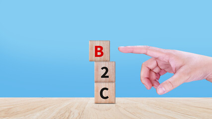Business to customer, B2C, BTC marketing concept, Hand touching wooden cubes with abbreviation B2C...