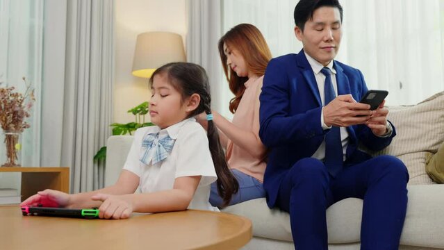 Family don't care about each other. Asian parents ignore their child and looking at their mobile phone at home, gadgets dependence overuse internet social media addiction on sofa living room