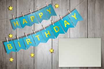 Happy birthday greeting text hanging on the rope with empty paper for copy space