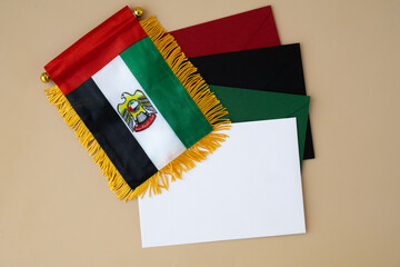 Colorful envelopes template sample National symbol of UAE. United Arab Emirates small flag with Peregrine falcon on neutral beige background. Copy space for your text. Concept of National day