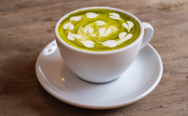 Top view of a cup of matcha green tea with milk cream On the wooden table in the living room in the morning healthy food concept