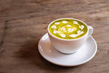 Cup of matcha green tea with milk cream On the wooden table in the living room in the morning healthy food concept