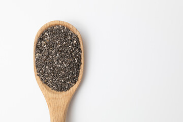Chia seeds on a wooden spoon isolated against a white background.