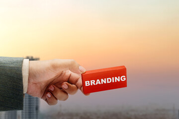 Business hand showing wooden block with branding text