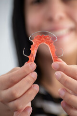 happy person showing his hawley retainer, concept of oral health, orthodontics, orthopedics. selective focus